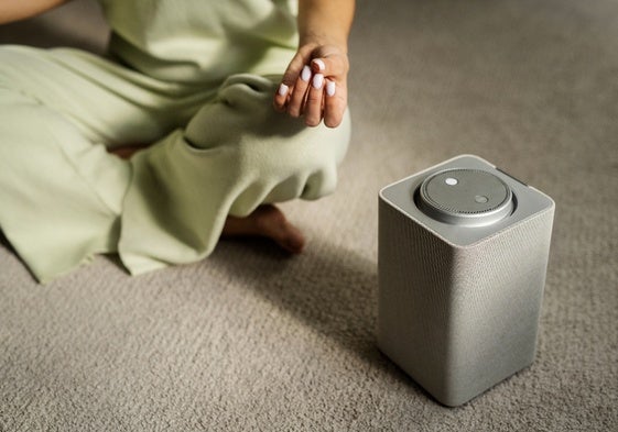 Mujer meditando con alto ángulo de altavoz bluetooth