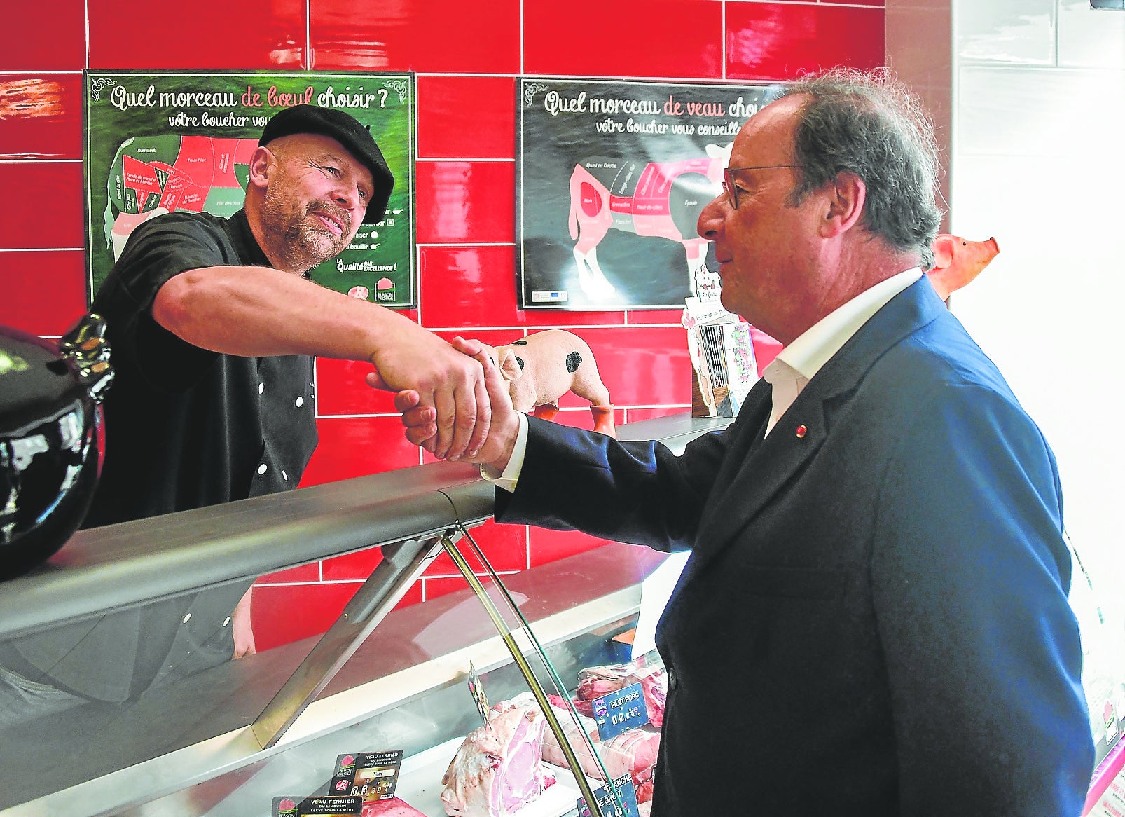 François Hollande, expresidente socialista francés, hace campaña en un mercado.