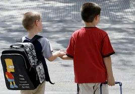 Dos niños con sus mochilas el primer día de colegio.