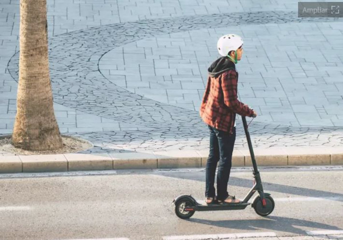 Un adolescente conduce un patinete eléctrico.