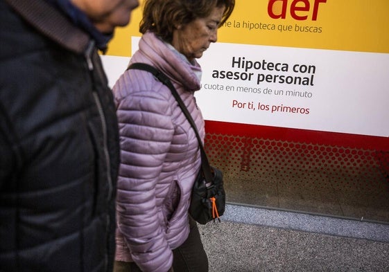 Clientes ante el escaparate hipotecario de un banco.