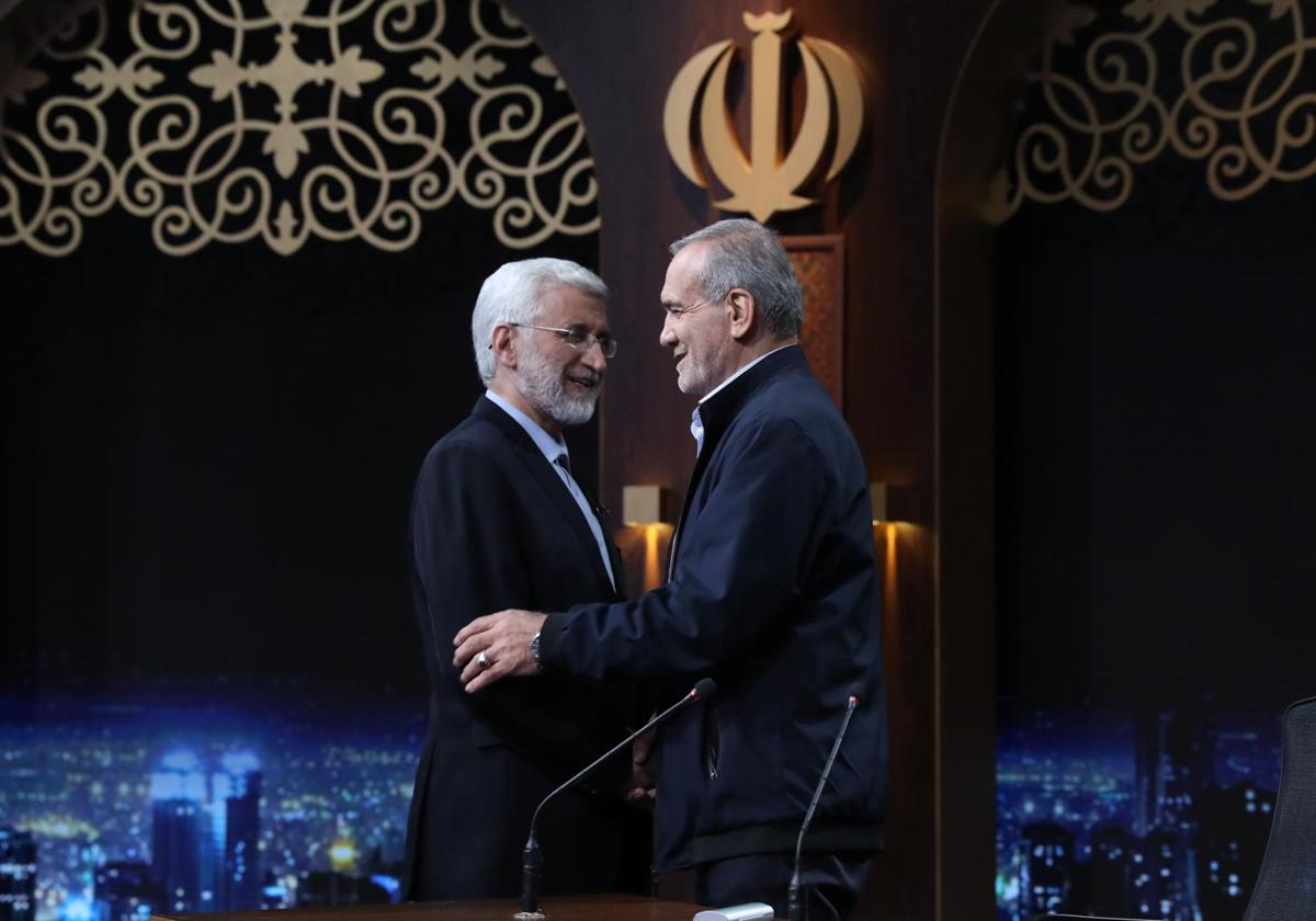 Los candidatos presidenciales iraníes Saeed Jalili y Masoud Pezeshkian se saludan antes de un debate televisivo celebrado el lunes.