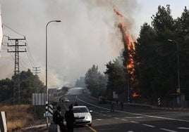 Bomberos israelíes apagan las llamas provocadas por proyectiles disparados desde el sur del Líbano.