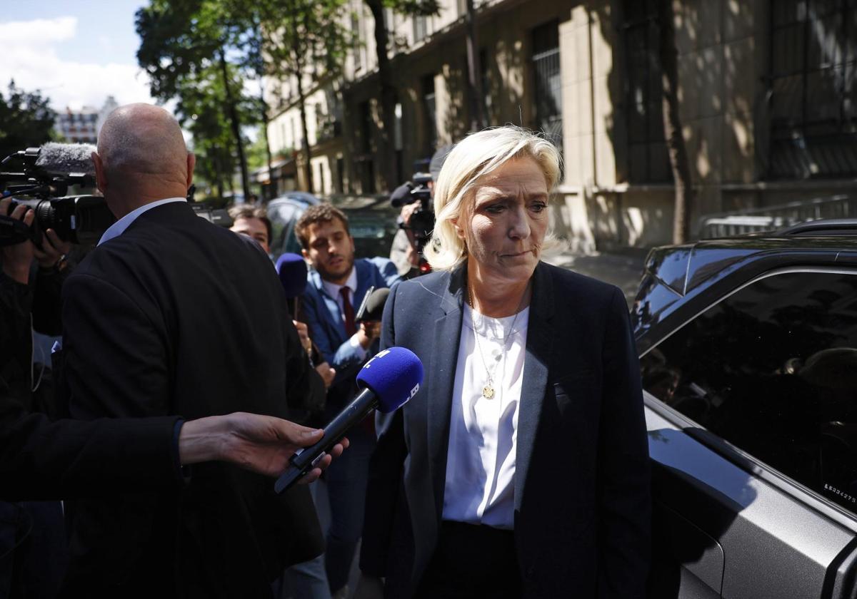 La líder ultraderechista Marine Le Pen es abordada por la prensa frente a la sede de su partido en París.