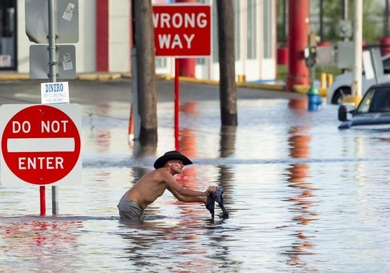 Un hombre se desplaza por una carretera inundada de la ciudad de Houston, en Texas.