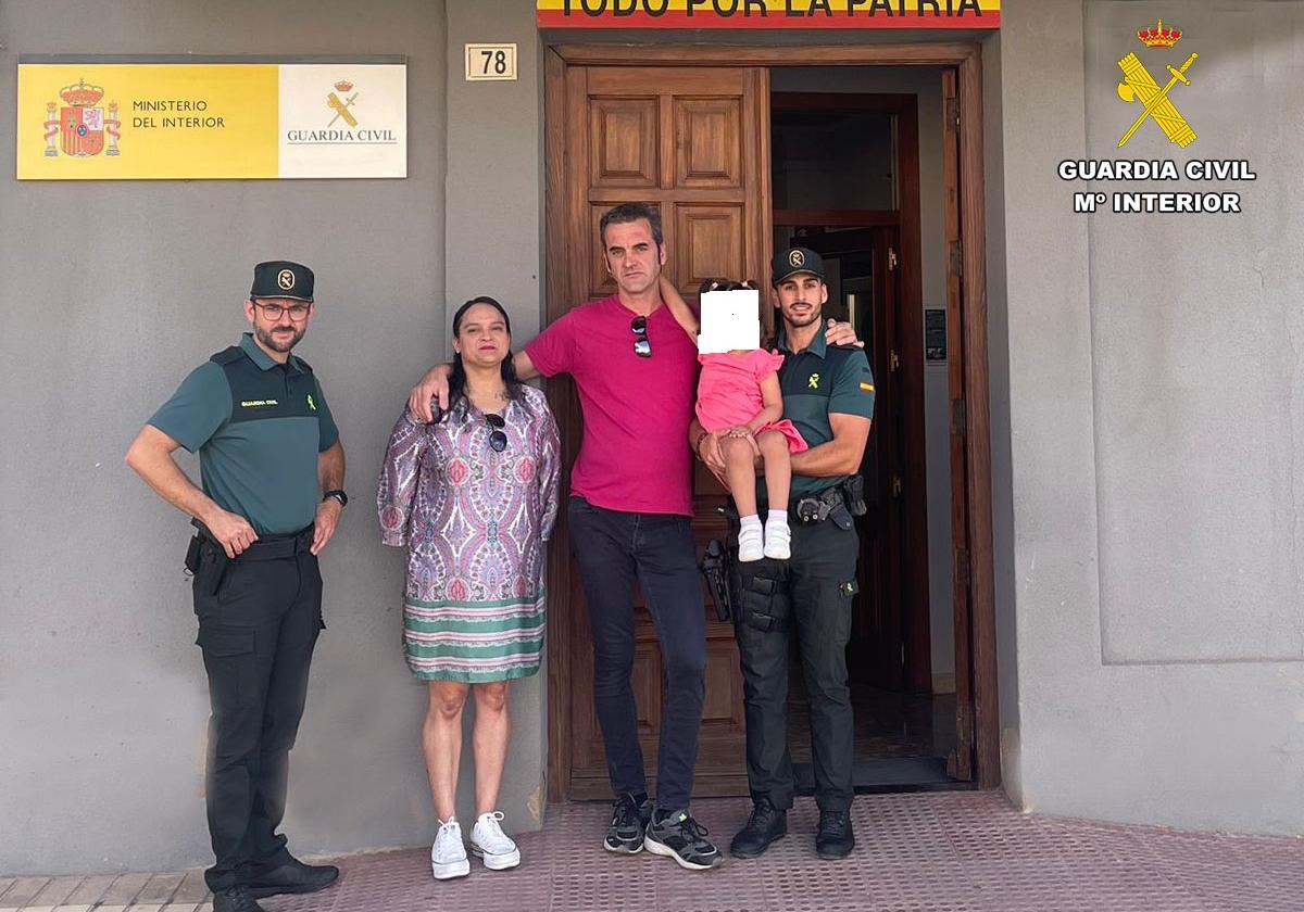 Los dos agentes posan con la niña y sus padres.