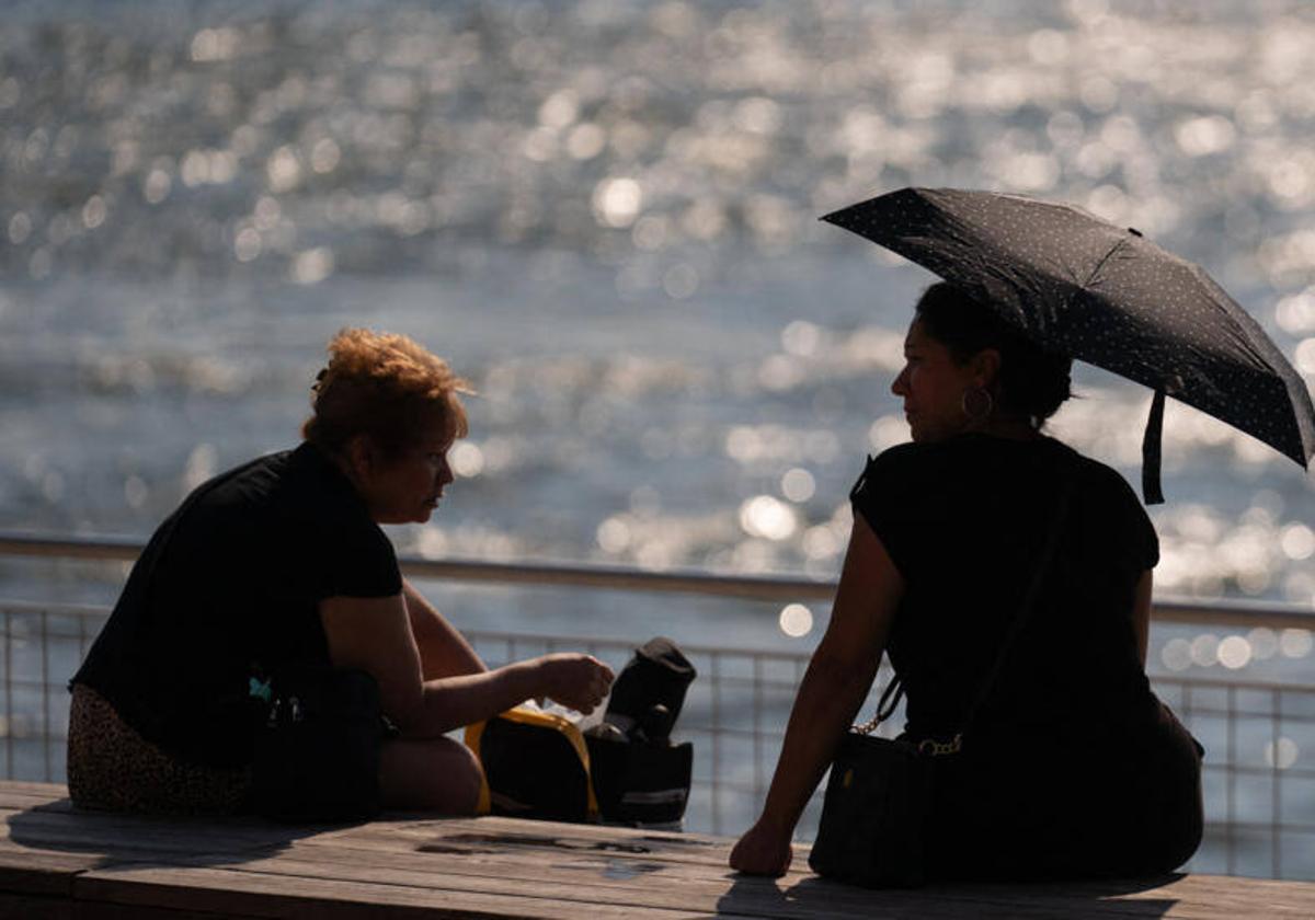 Los ciudadanos americanos se cubren como pueden para evitar el sol y las altas temperaturas.