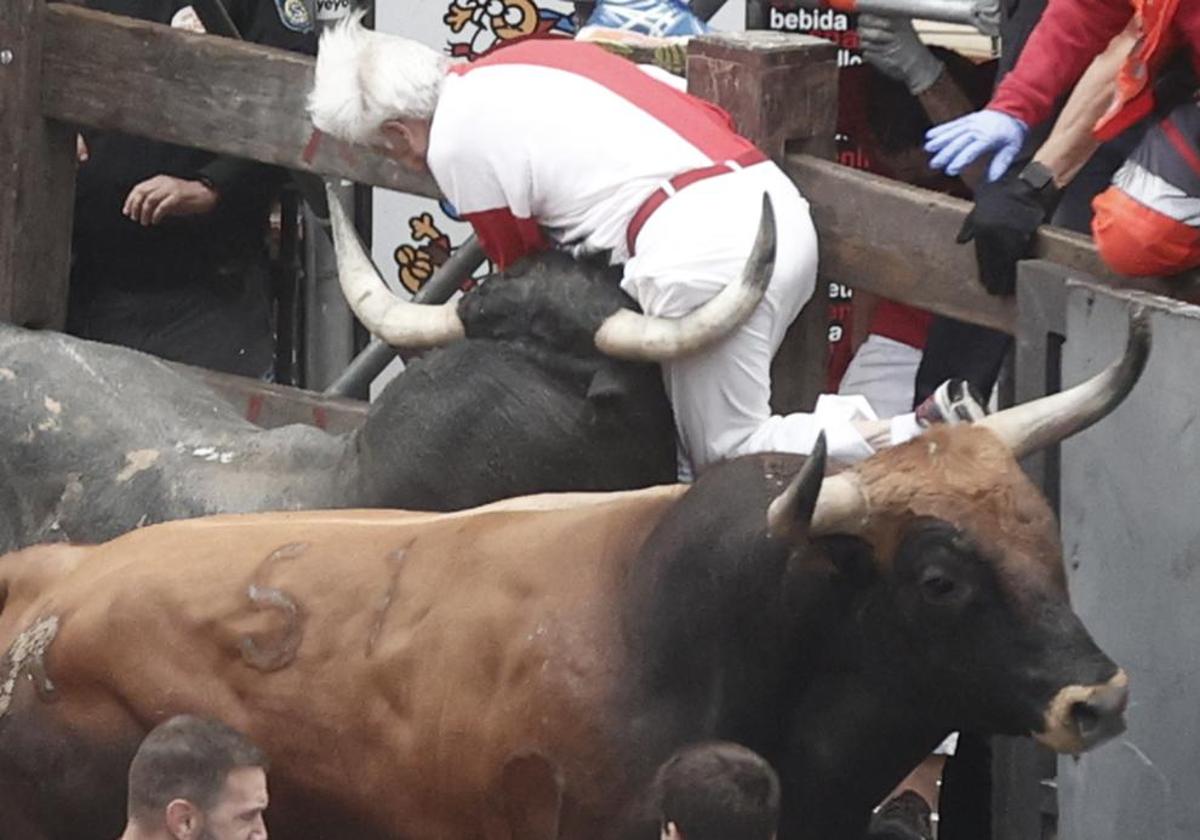 Un mozo es embestido por uno de los toros de la ganadería sevillana de Miura durante el último encierro de los Sanfermines 2024