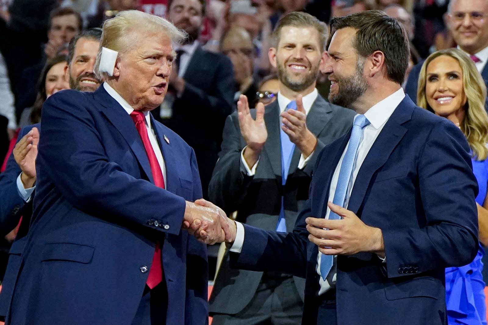 Donald Trump y su aspirante a la vicepresidencia de EE UU, J. D. Vance, se estrechan la mano durante la convención republicana en Milwaukee.