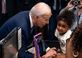 Biden se dirige a una niña durante una visita a un mercado de Las Vegas.