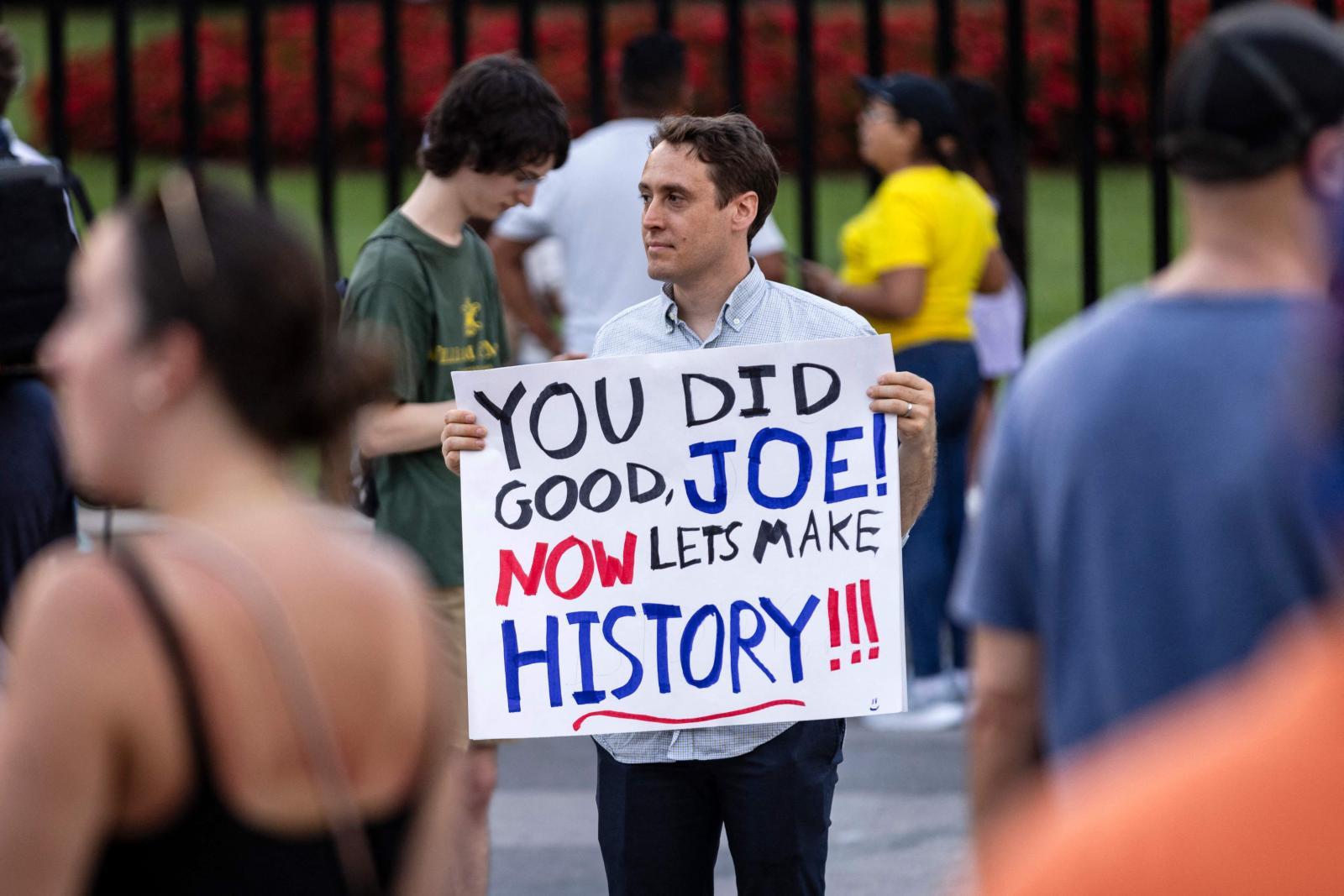 Un simpatizante demócrata agradece a Biden su legado delante de la Casa Blanca tras conocer su renuncia.