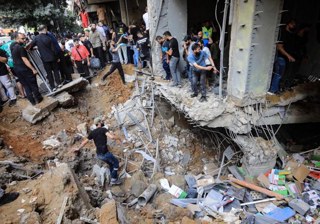 Residentes buscan supervivientes entre las ruinas del edificio bombardeado en la capital libanesa.