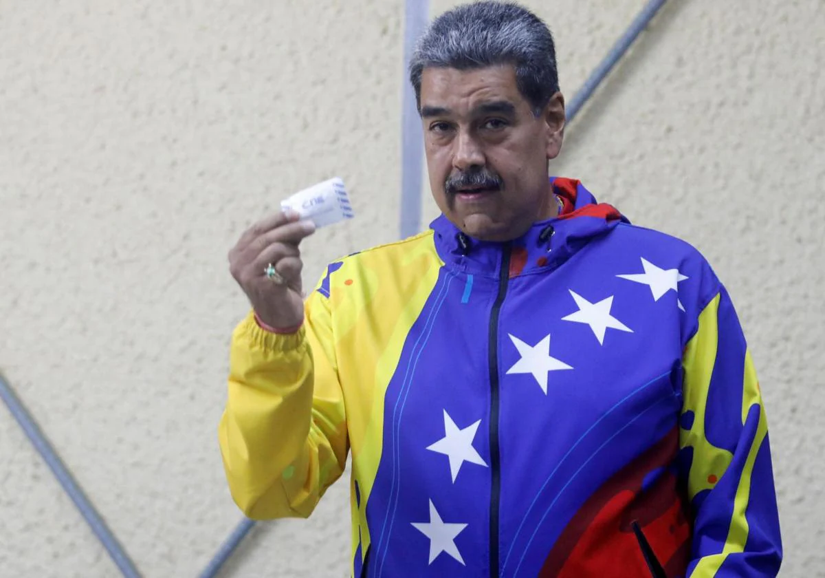 El presidente Maduro muestra su papeleta antes de introducirla en la urna.