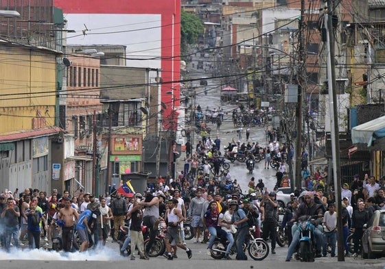 Manifestantes acuden con un retrato de Hugo Chávez a jalear a Maduro delante del Palacio de Miraflores.