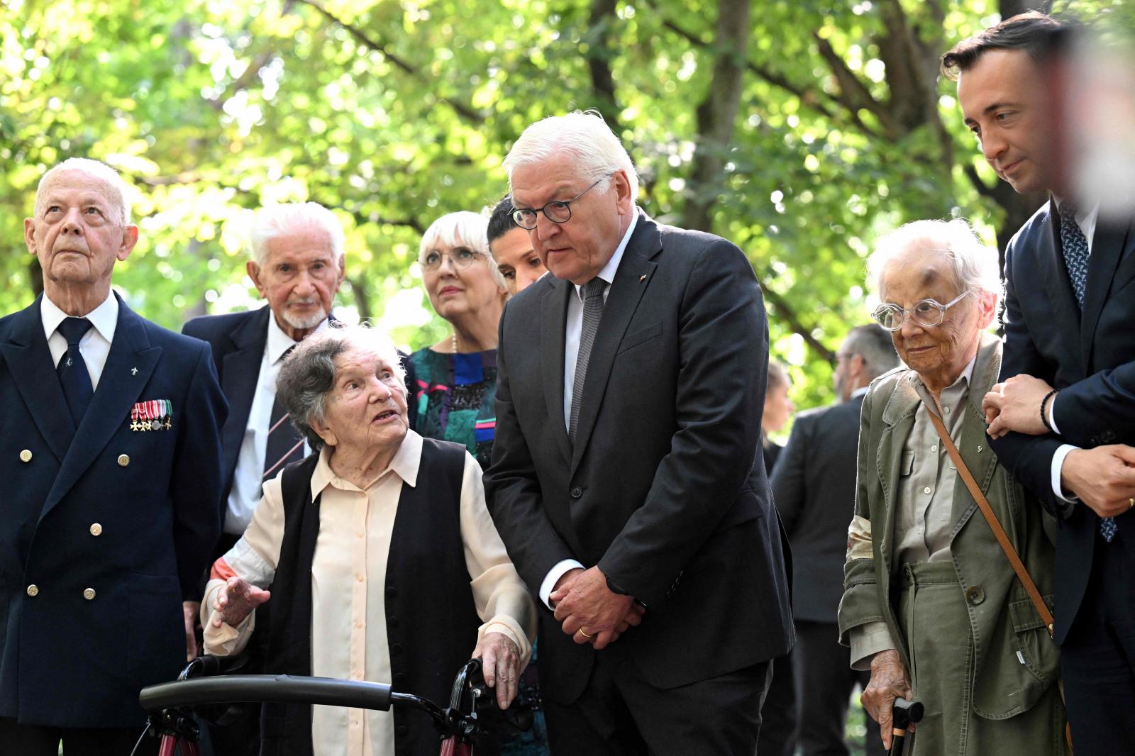 El presidente de Alemania, Frank-Walter Steinmeier, escucha a una veterana y exdisidente polaca en el cementerio de los insurgentes.