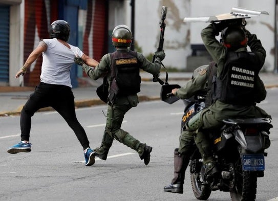 Miembros de la Guardia Nacional detienen a un manifestante en Caracas.