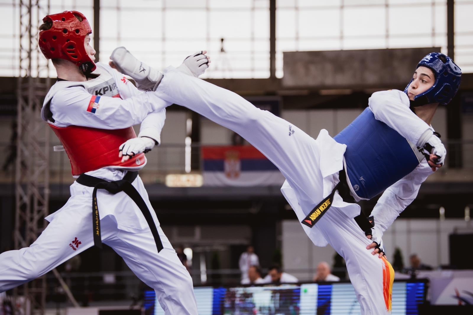 Adrián Vicente, de azul, lanzando una patada en un combate del Campeonato de Europa de taekwondo