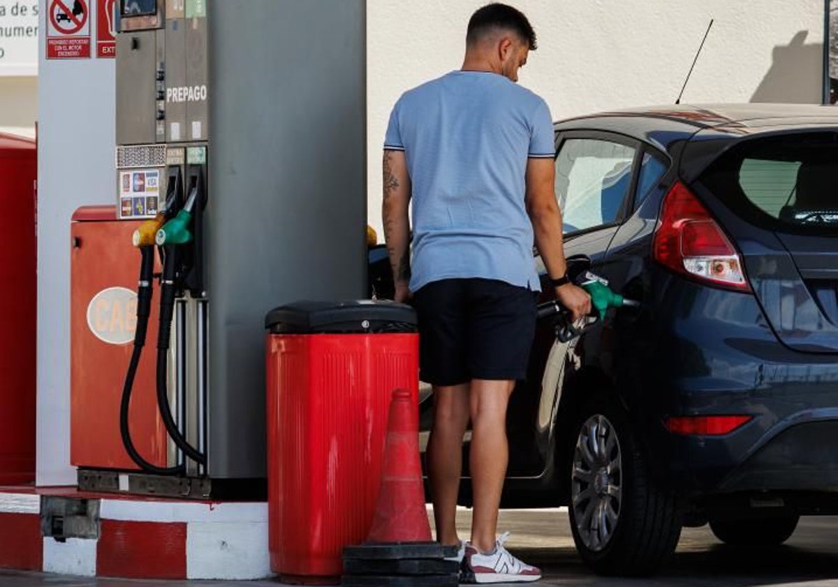 Un hombre reposta en una estación de servicio.