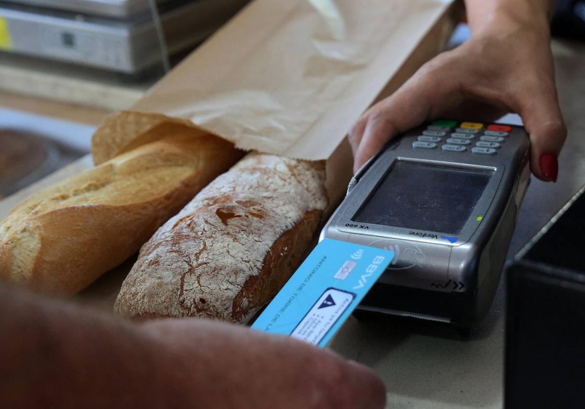 Un cliente paga el pan con su tarjeta.