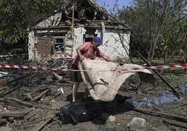 Un vecino cubre el cadáver de la mujer que resultó muerta en Zaporiyia.