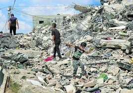 Varios niños caminan sobre los escombros de una vivienda destruida por un bombardeo israelí sobre Kafr Dan, cerca de la ciudad cisjordana de Yenin.