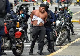 Agentes de la Policía bolivariana detienen a un manifestante en las calles de Caracas.