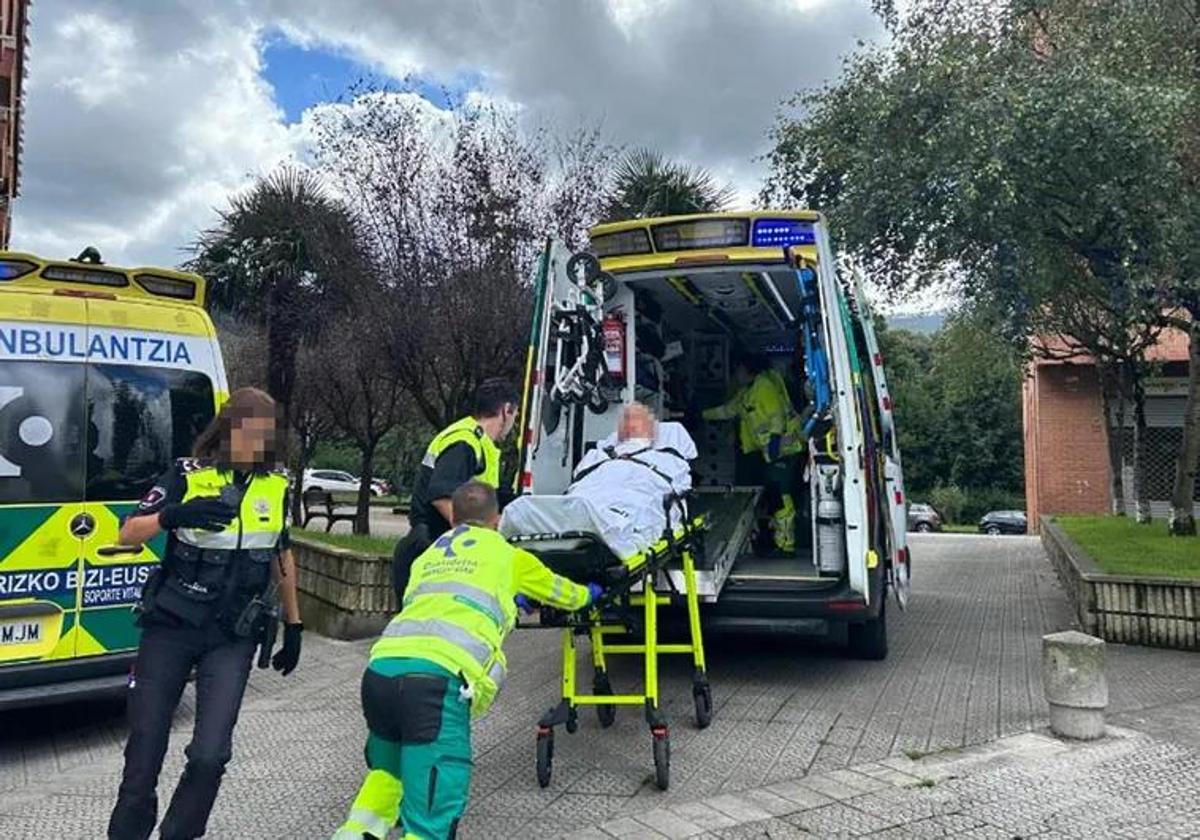 El padre del agresor es evacuado en una ambulancia.