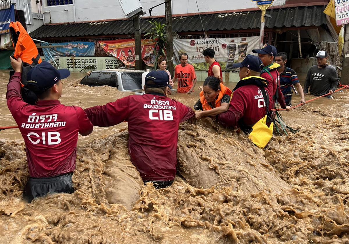 Imagen principal - Equipos de salvamento trabajan en el rescate de supervivientes, algunos de los cuales han tenido que refugiarse en los tejados por las graves inundaciones del tifón 'Yagi'.