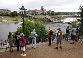 Viandantes observan el puente Carola parcialmente derrumbado sobre el río Elba, en el centro de la ciudad de Dresde.