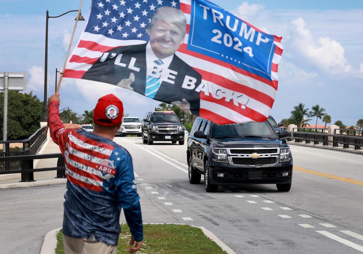 Un simpatizante de Trump le muestra su apoyo al paso de la caravana del expresidente por una calle de Florida.