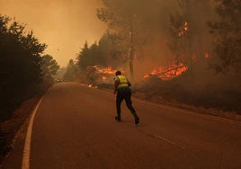 Un policía corre por una carretera rodeada por el fuego en Sao Pedro do Sul (Portugal).