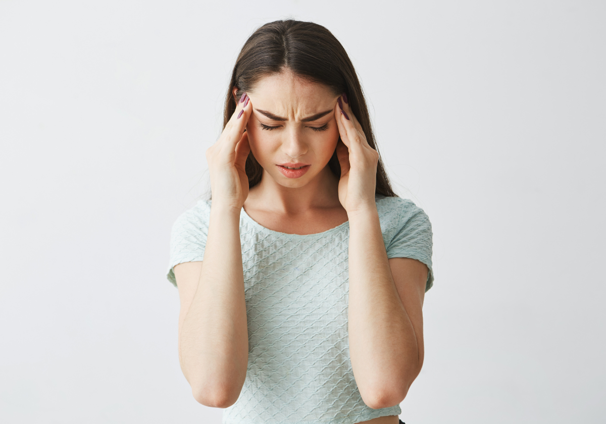 Mujer con migraña, sufre por el dolor de cabeza.