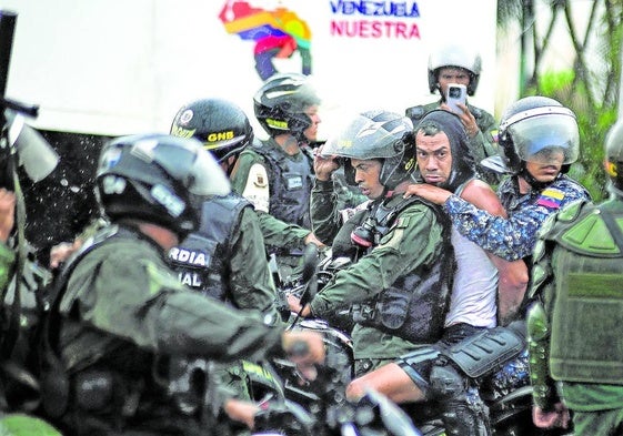 Los militares se llevan en moto a un hombre que protestaba el 29 de julio.