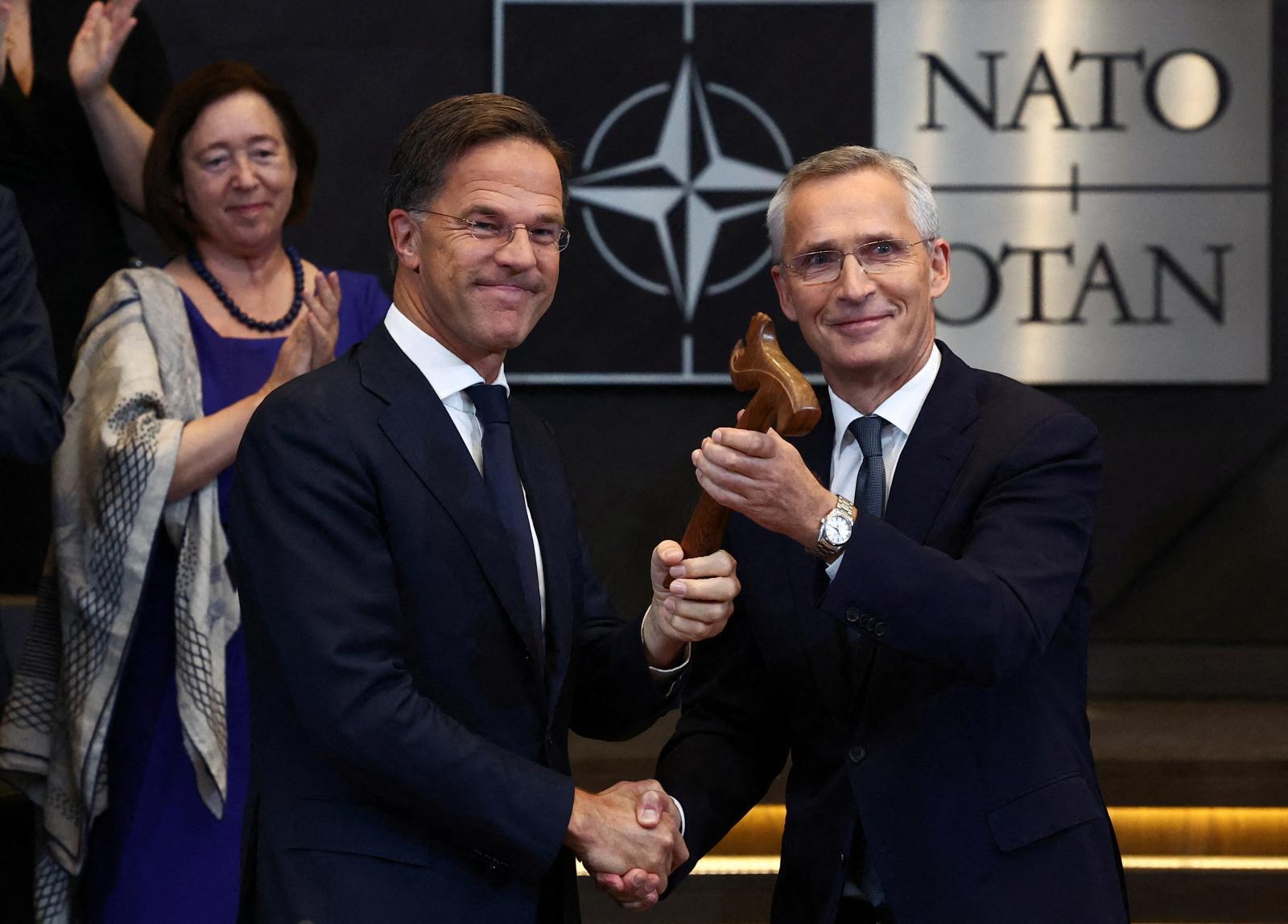 Mark Rutte recibe el mazo de madera que simboliza la autoridad de la OTAN de manos de Jens Stoltenberg.