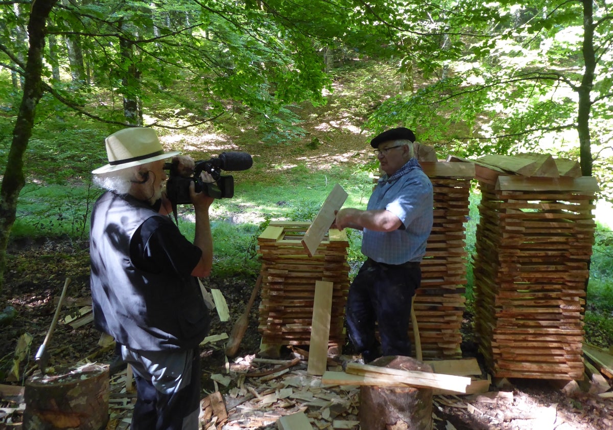 Imagen principal - De arriba abajo: Eugenio graba en un bosque navarro a un maderista preparando las tablillas de haya para la construcción de un tejado. Hilario Artigas prepara una caseta de carbonero en Agüero (Huesca) y un retrato del autor de '100 oficios para el recuerdo'.