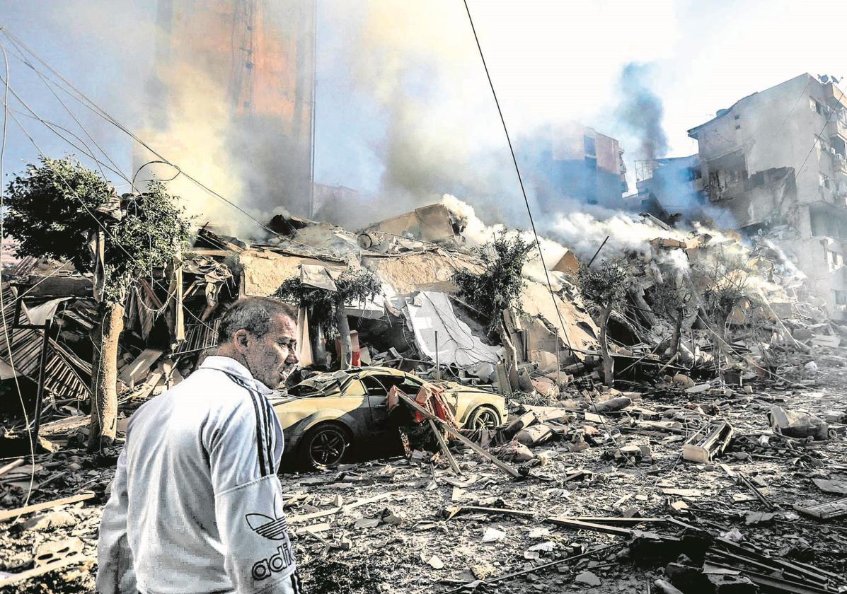 Un hombre camina entre los escombros tras un bombardeo israelí en un barrio del sur de Beirut.