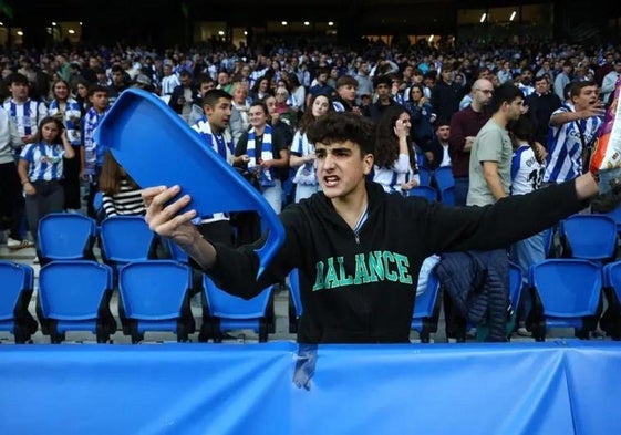 Un joven seguidor de la Real muestra uno de los trozos de silla arrojados por los ultras del Anderlecht