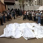 Palestinos rezan junto a los cadáveres de los miembros de la familia AbúTaima, muertos en un ataque aéreo israelí, en el campo de refugiados de Jan Younis.