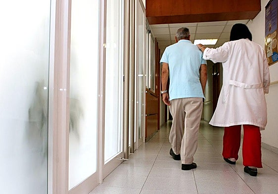 Una enfermera acompaña a un paciente de alzhéimer.