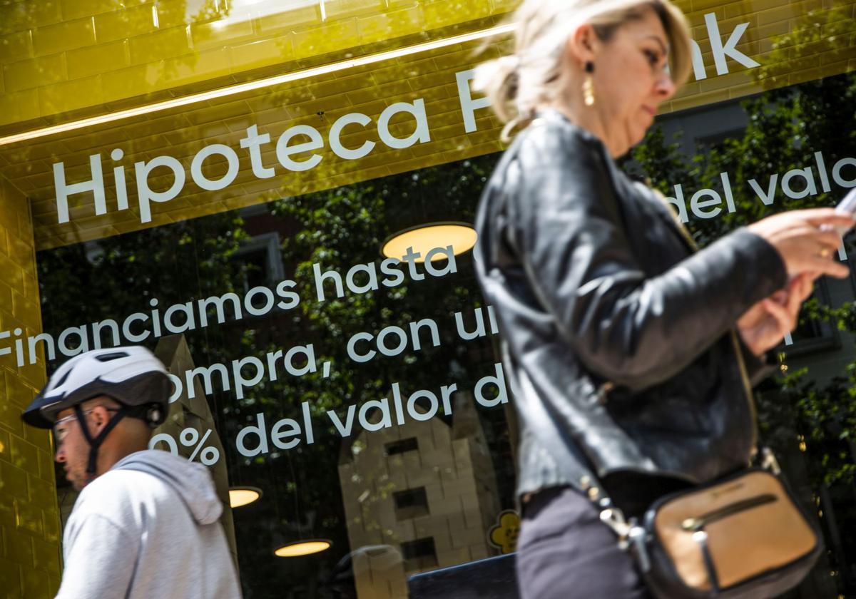 Dos ciudadanos frente a un escaparate bancario.