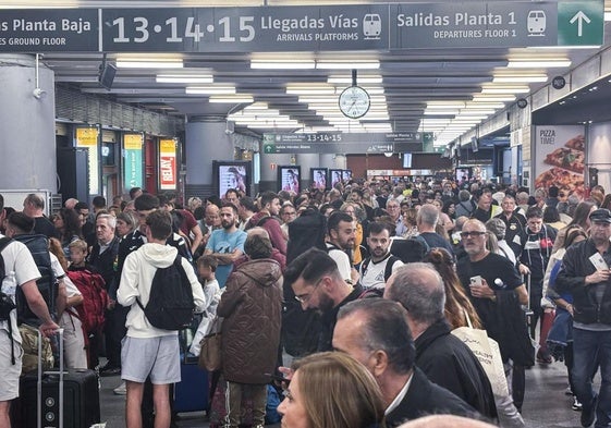 Decenas de pasajeros en el interior de la estación madrileña de Atocha tras cortarse este sábado el tráfico ferroviario en la zona.