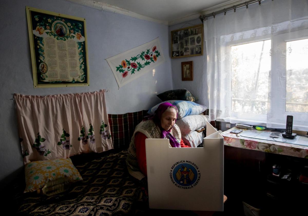 Una anciana ejerce su derecho al voto desde su casa.