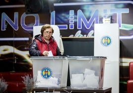 Una mujer deposita su voto en un colegio electoral de la localidad moldava de Hrusevo.