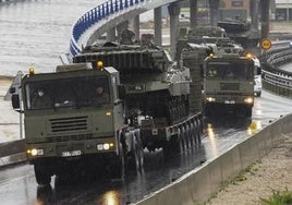 Una hilera de camiones remolca los carros de combate en los accesos a Santander, camino del Puerto de Santander.