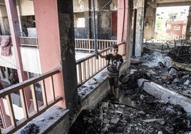 Un niño camina entre los escombros de la escuela gazatí de Nuseirat atacada por las tropas hebreas.