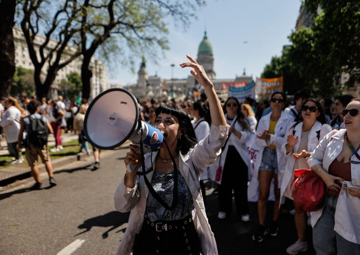 Imagen secundaria 1 - Trabajadores del sector de la salud, en las dos primeras imágenes, y de la educación, en la última, protestan contra los recortes de Milei en los sectores.