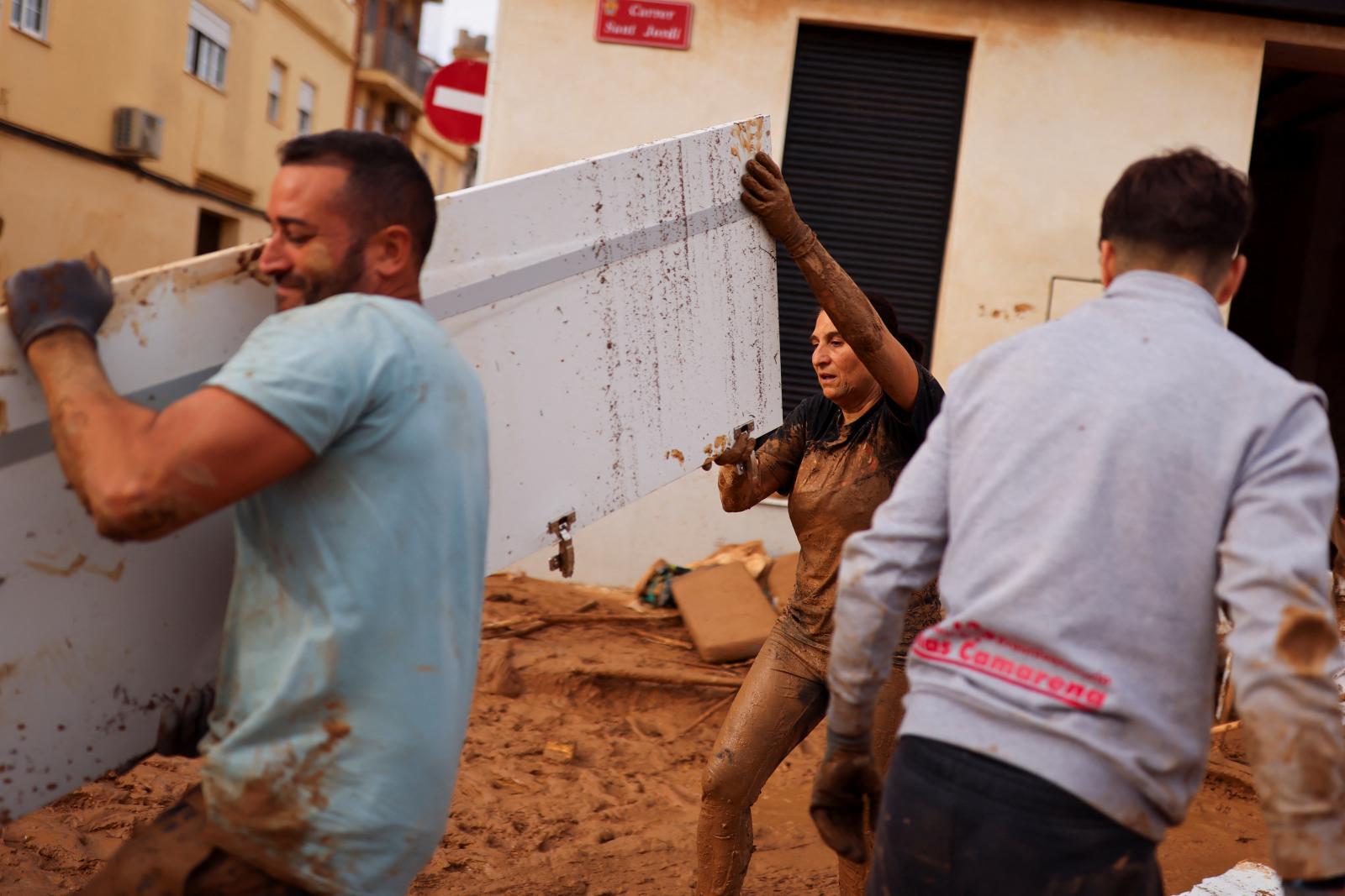 Voluntarios ayudan a retirar escombros en una calle de Paiporta, Valencia