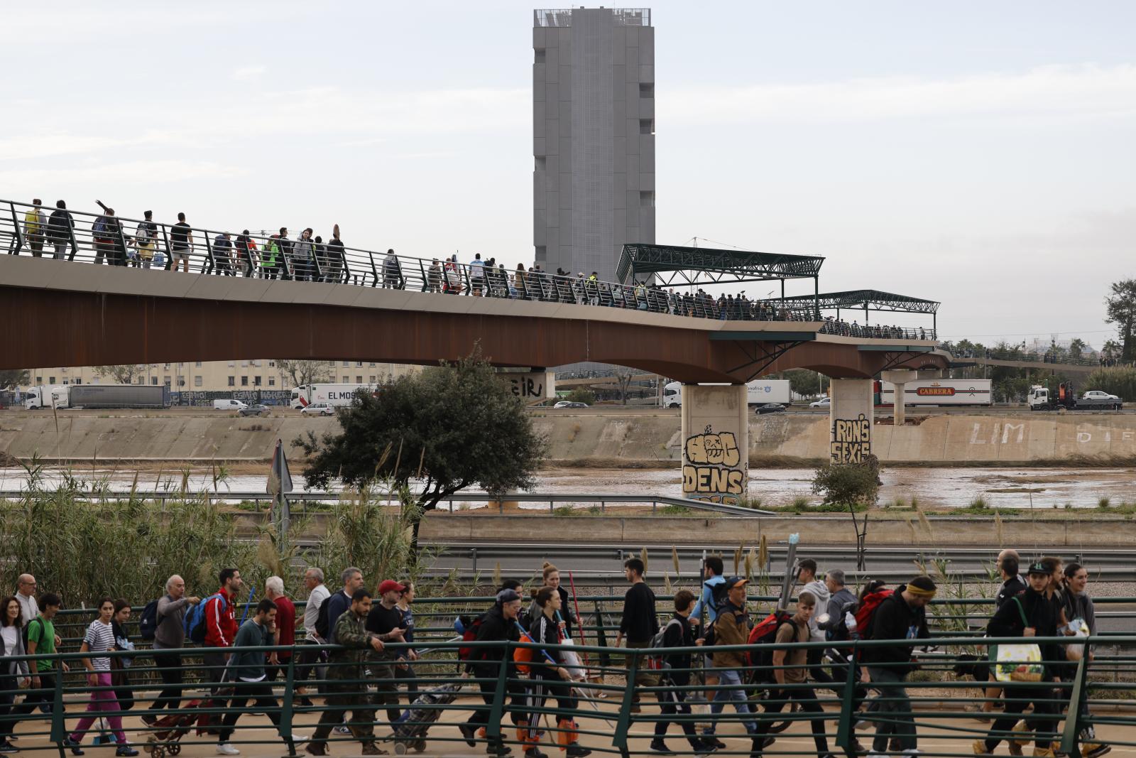 Cientos de ciudadanos con herramientas, alimentos y enseres recorren los barrios del sur de Valencia para tratar de ayudar a los damnificados