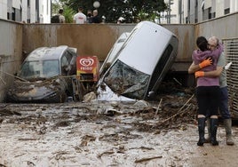 Dos vecinos se abrazan en Paiporta (Valencia)