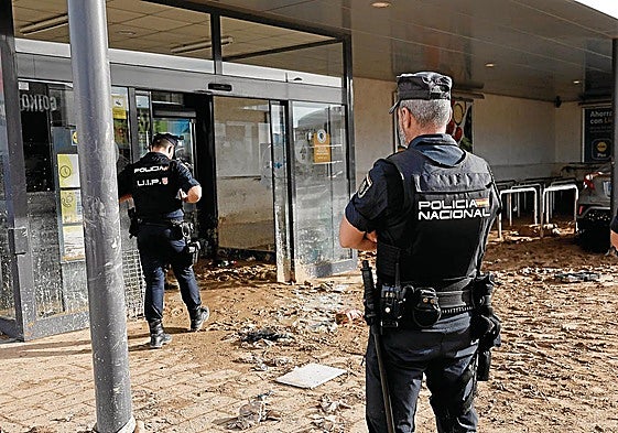 Policías nacionales vigilan los accesos al centro comercial MN4 en la localidad valenciana de Alfafar, una de las más afectadas por la DANA.